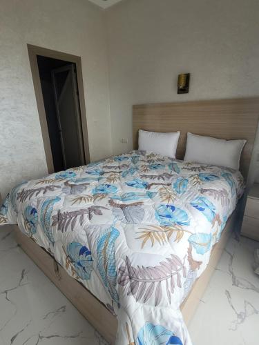 a bedroom with a bed with a colorful comforter at jaws wave imsouane in Imsouane
