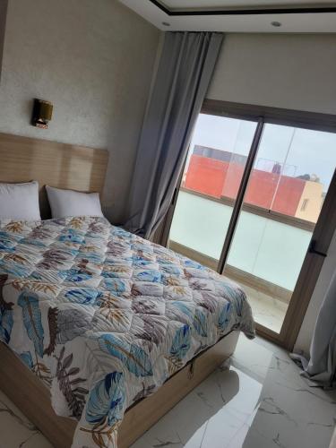 a bedroom with a bed and a large window at jaws wave imsouane in Imsouane