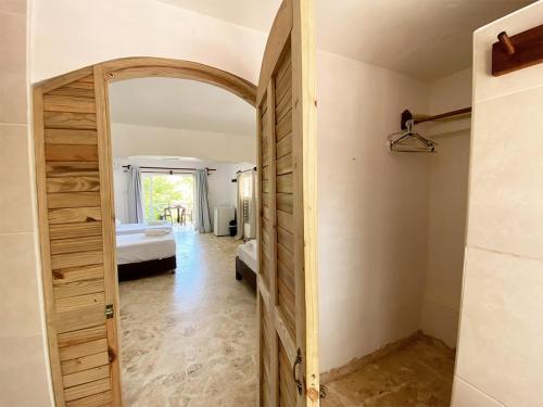 a hallway with a door to a room with a bed at Surfbreak B&B in Cabarete