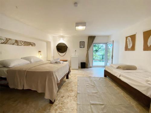 a bedroom with two beds and a hallway with a window at Surfbreak B&B in Cabarete