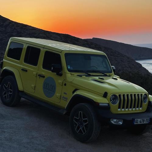 a yellow jeep parked on the beach at sunset at Maison Meltem in Agia Pelagia