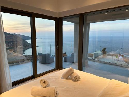 a bedroom with two towels on a bed in front of a window at Maison Meltem in Agia Pelagia