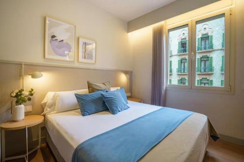 a bedroom with a large bed and a window at Fisa Rentals Ramblas Apartments in Barcelona