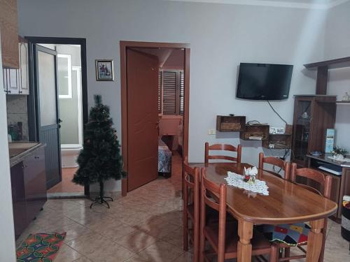 a living room with a table and a christmas tree at Beqiri Apartment in Belsh
