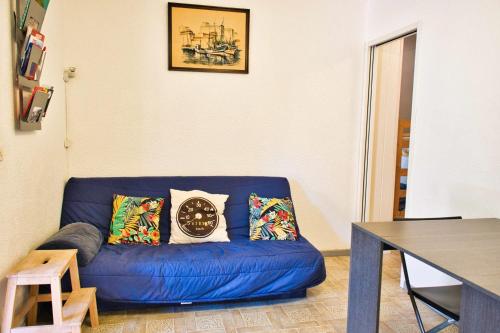 - un canapé bleu avec des oreillers dans le salon dans l'établissement T3 with parking and terrace next to the sea, à Port-Leucate
