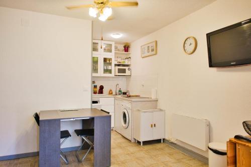 Il comprend une cuisine avec une table et une télévision murale. dans l'établissement T3 with parking and terrace next to the sea, à Port-Leucate