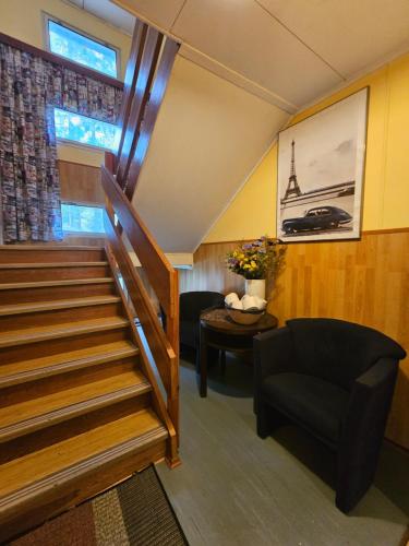 a room with a staircase and a couch and a chair at Penzion Poslední míle in Milovy