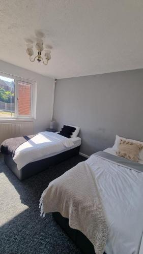 a bedroom with two beds and a window at Doncaster-House-Sleeps8-Parking-Garden in Doncaster