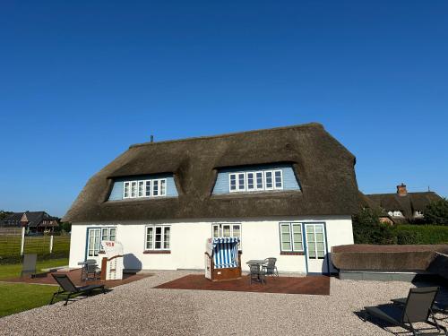 a thatch roofed house with a thatched roof at Haus Amanda in Norddorf