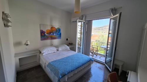 Biała sypialnia z łóżkiem i balkonem w obiekcie Zoe Pension w mieście Ermioni