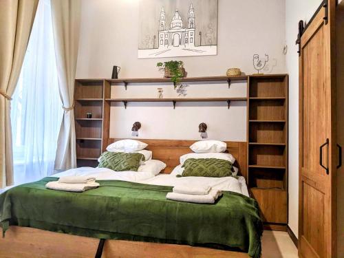 um quarto com uma cama grande e lençóis verdes em Ó 38 Luxe Loft em Budapeste
