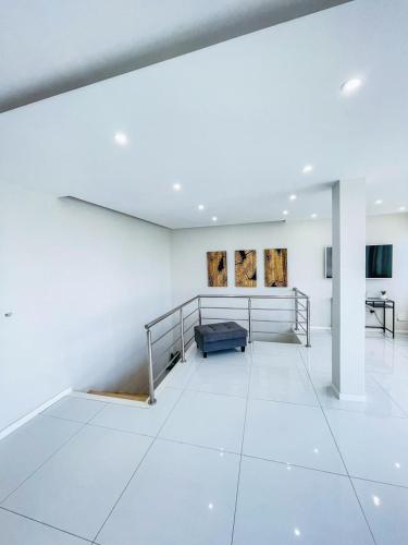 a white room with a bed and paintings on the wall at Résidence Cazino Apartamentos in Praia