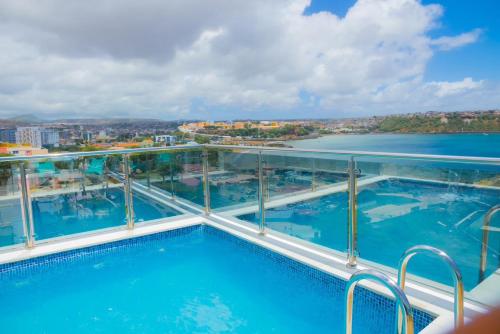 a swimming pool on the top of a building with water at Résidence Cazino Apartamentos in Praia