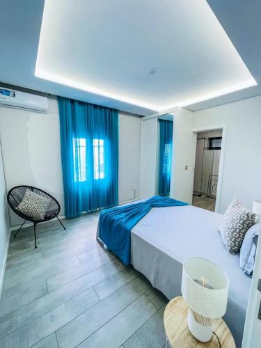 a bedroom with a large bed and blue curtains at Résidence Cazino Apartamentos in Praia