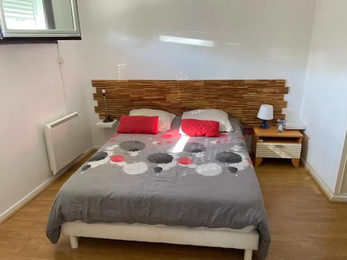 ein Schlafzimmer mit einem großen Bett mit zwei roten Kissen in der Unterkunft DUPLEX PLEIN CENTRE VILLE DE MONTPELLIER in Montpellier