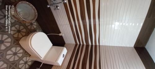 a bathroom with a toilet and a mirror at Perumaal Homestay in Munnar
