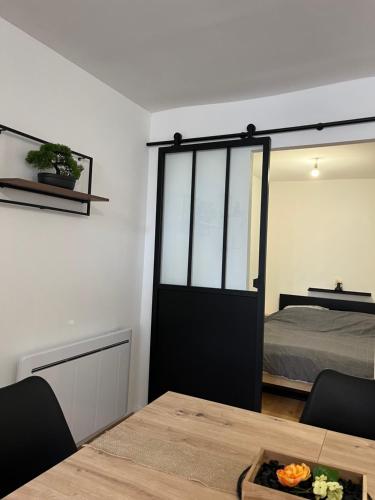Cette chambre comprend un lit et une table avec une porte. dans l'établissement Appartement Chic & Élégant, à Saint-Dizier