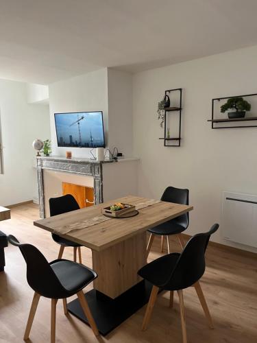 a living room with a wooden table and chairs at Appartement Chic & Élégant in Saint-Dizier