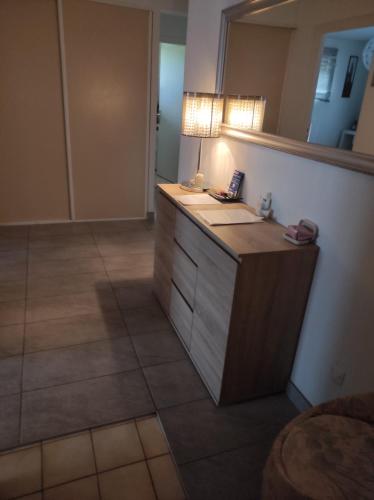 La salle de bains est pourvue d'un comptoir avec un miroir et un lavabo. dans l'établissement Très bel appartement 3 pièces + jardin + parking, à Divonne-les-Bains