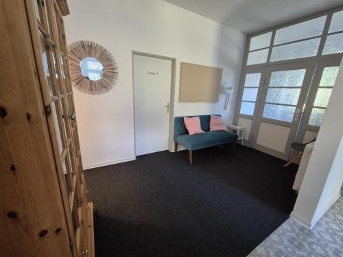 a room with a blue chair and a mirror at Gästehaus bed & kitchen in Schleswig