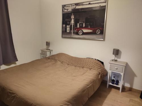 - une chambre avec un lit et une photo d'une voiture sur le mur dans l'établissement Très bel appartement 3 pièces + jardin + parking, à Divonne-les-Bains