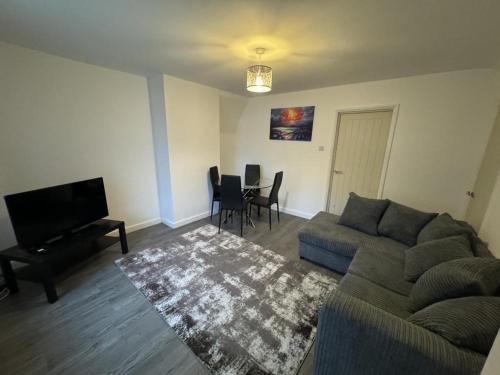 a living room with a couch and a tv and a table at 3 Bed-Sleeps 5- Garden-Pets-Parking in Wolverhampton