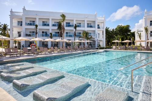 a swimming pool with chairs and a hotel at Riu Palace Bavaro - All Inclusive in Punta Cana