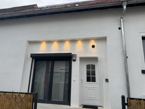 a white house with a door and lights on it at Ferienwohnung Nickolai in Wahlheim