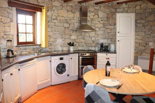 a kitchen with a table and a sink and a stove at La tour du Périgord in Beaupouyet