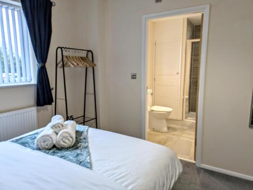 a bedroom with a bed and a bathroom with a toilet at Tempting Telford 4 bed house in Telford