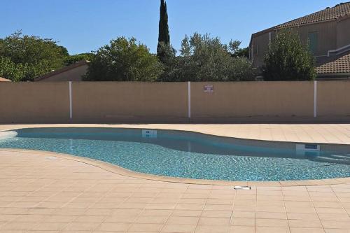 une piscine vide dans une arrière-cour avec une clôture dans l'établissement La Malou, à Portiragnes
