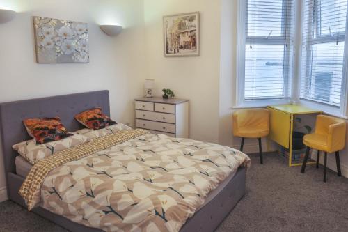 a bedroom with a bed and a desk and windows at Bournemouth Cozy 3 Bedrooms Near Beach With Parking in Bournemouth
