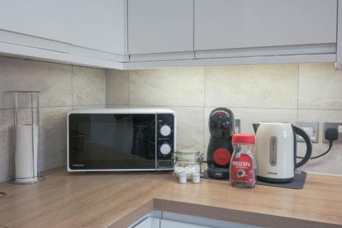 a microwave sitting on top of a counter in a kitchen at Bournemouth Cozy 3 Bedrooms Near Beach With Parking in Bournemouth