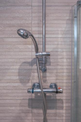 a shower head with a hose attached to a wall at Bournemouth Cozy 3 Bedrooms Near Beach With Parking in Bournemouth