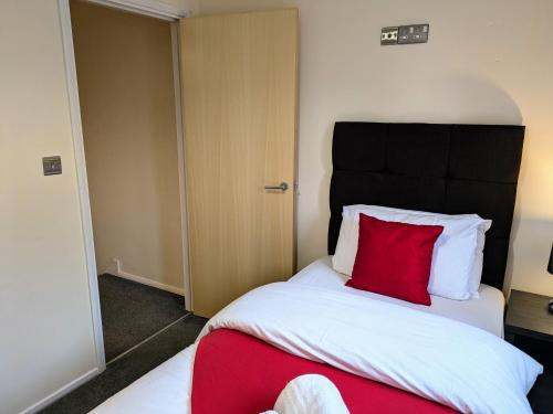 a bedroom with a bed with a red pillow at Tempting Telford 4 bed house in Telford