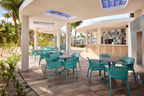 a restaurant with green chairs and tables and a bar at Riu Palace Bavaro - All Inclusive in Punta Cana