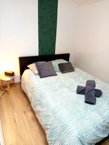 - un lit avec deux oreillers et un chapeau dans l'établissement Escale - Maison - Nantes aéroport, à Bouguenais