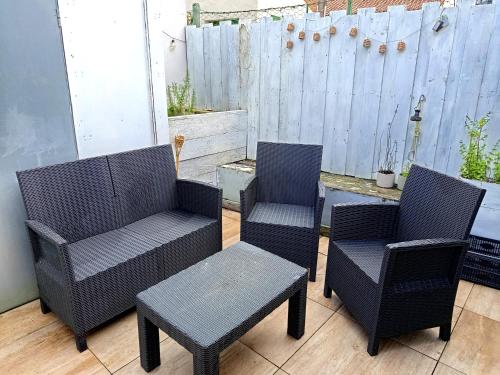 three chairs and a table on a patio at Escale - Maison - Nantes aéroport in Bouguenais