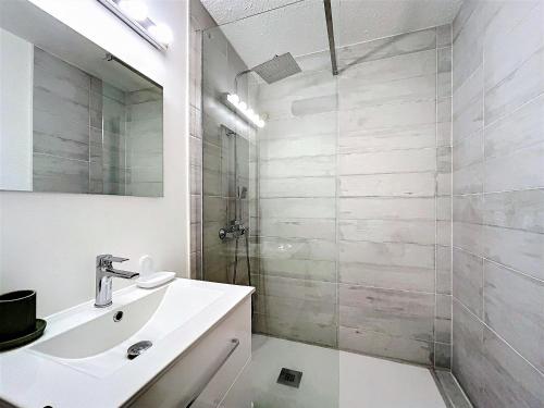 une salle de bain blanche avec un lavabo et une douche dans l'établissement Studio lumineux skis aux pieds avec balcon, piscine et casier à skis - FR-1-267-294, à Villarembert