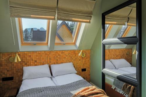 a bedroom with two beds and two windows at Osada Widokowa Kościelisko in Kościelisko