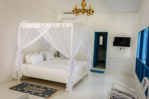 a bedroom with a white bed with a canopy at The Tranquilite' in Anuradhapura