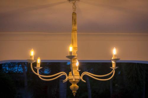 a chandelier with candles hanging from a ceiling at The Tranquilite' in Anuradhapura