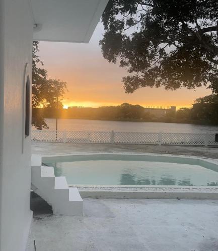 a swimming pool with a sunset in the background at The Tranquilite' in Anuradhapura