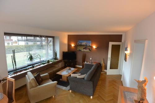 a living room with a couch and chairs and a tv at Haus Erli in Mittenwald
