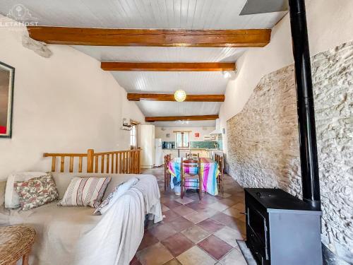 een woonkamer met een bank en een tafel bij Charme rustique avec jardin privé "Au Pastel" in Soupex