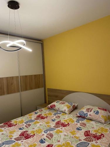 una camera da letto con un letto con copriletto floreale di APARTMANS AJAN OHRID a Ohrid