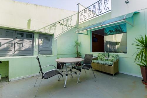 a patio with a table and chairs and a couch at VELINN Pousada Entre Praias in Ubatuba
