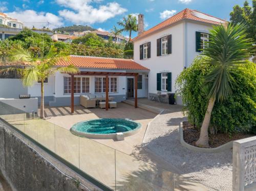 a villa with a swimming pool in front of a house at Casa Trollis by Holiday Rental Madeira in Funchal