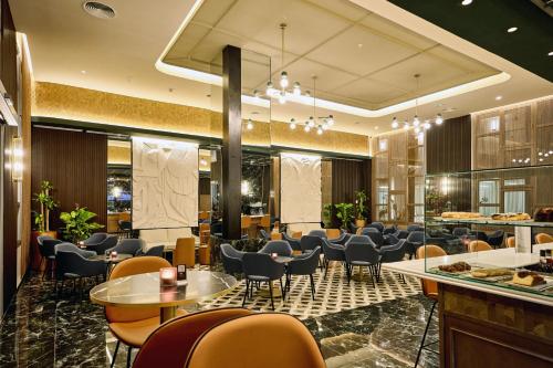 a restaurant with chairs and tables in a lobby at Riu Palace Bavaro - All Inclusive in Punta Cana