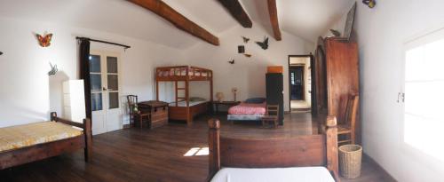 a living room with wooden floors and a room with furniture at Mas de Regardebon in Mazan